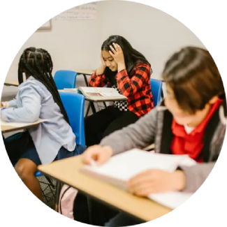 Students reading at desks in a classroom, creating a focused environment for learning and self-confidence.