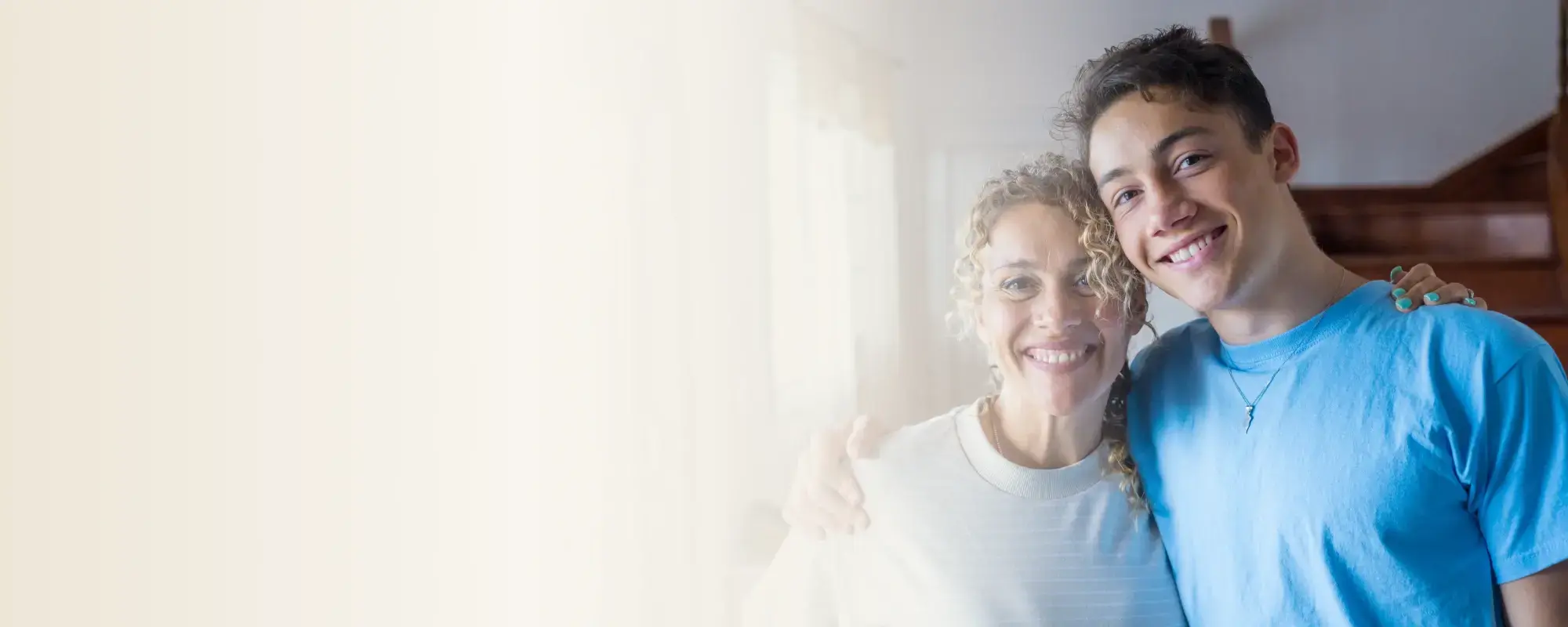 Adulto y adolescente sonriendo juntos, simbolizando una relación familiar feliz y de apoyo. 