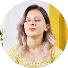 A smiling female with closed eyes is meditating