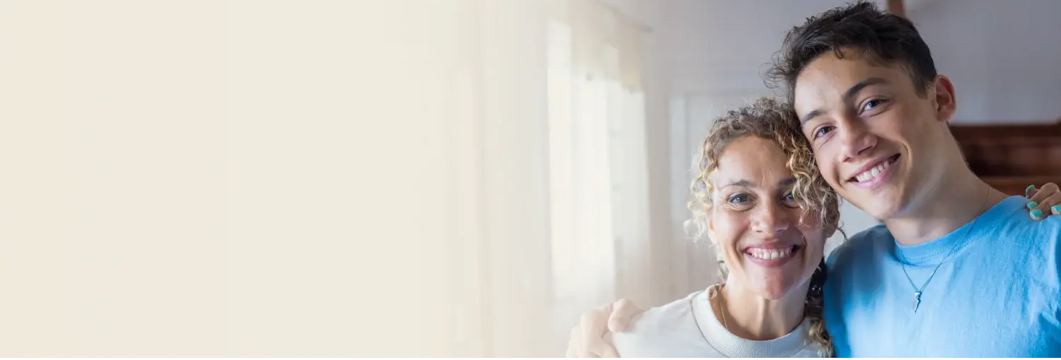 Mother and teen son smiling together, symbolizing a happy, supportive parent-teen relationship"