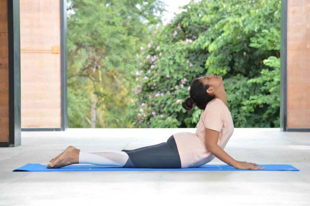 Yoga - lying on the floor on tummy with shoulder and neck stretched upwards in cobra pose