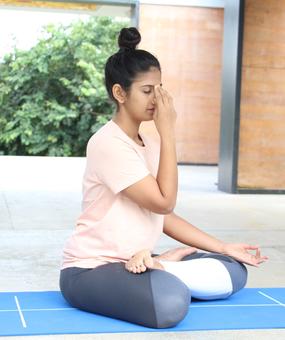 Lady sitting & doing Nadi Shodhan Pranayama