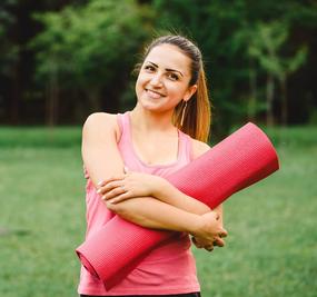 Women ready for yoga holding yoga mat in hand