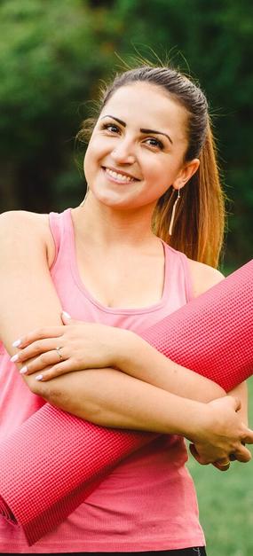 Women ready for yoga holding yoga mat in hand