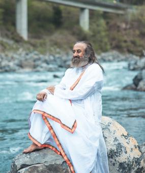 Gurudev sitting on rock on the bank of Ganga