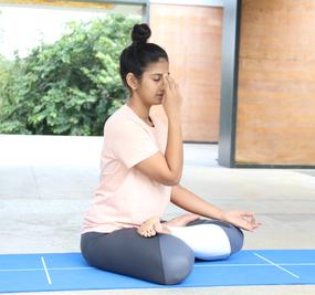 Lady sitting & doing Nadi Shodhan Pranayama