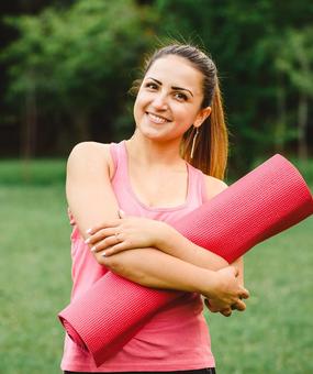 Women ready for yoga holding yoga mat in hand