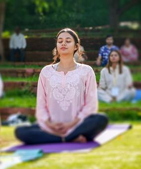 group meditation in lawn girl smiling at blr ashram