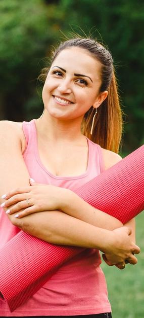 Women ready for yoga holding yoga mat in hand