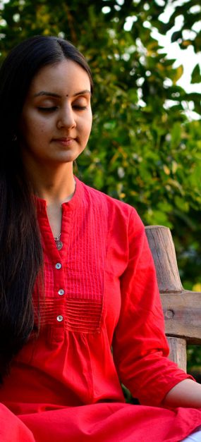 A young woman meditating on a bench in the woods