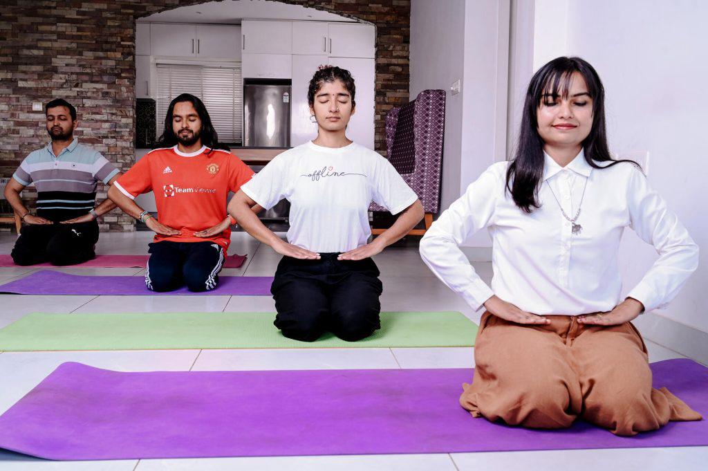 participants of happiness program doing pranayama in a room