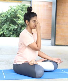 Lady sitting & doing Nadi Shodhan Pranayama