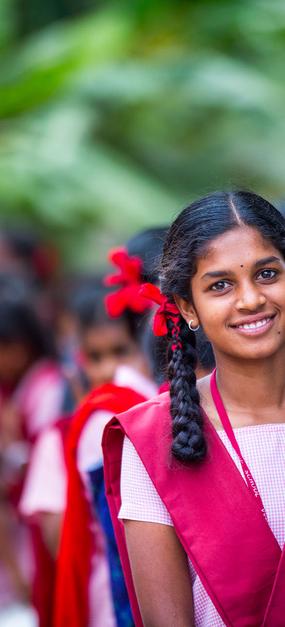 Free school girl smiling with group of girls in background