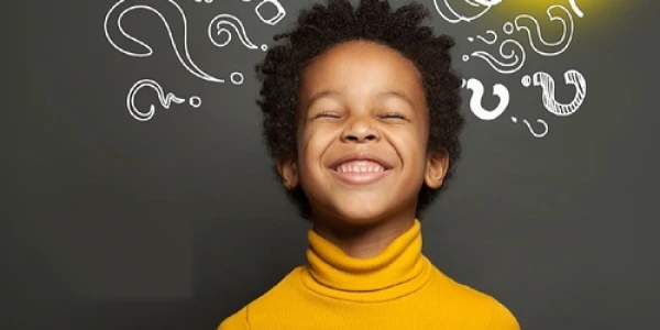 Young participant in yellow showing joy during intuition process training, surrounded by question marks